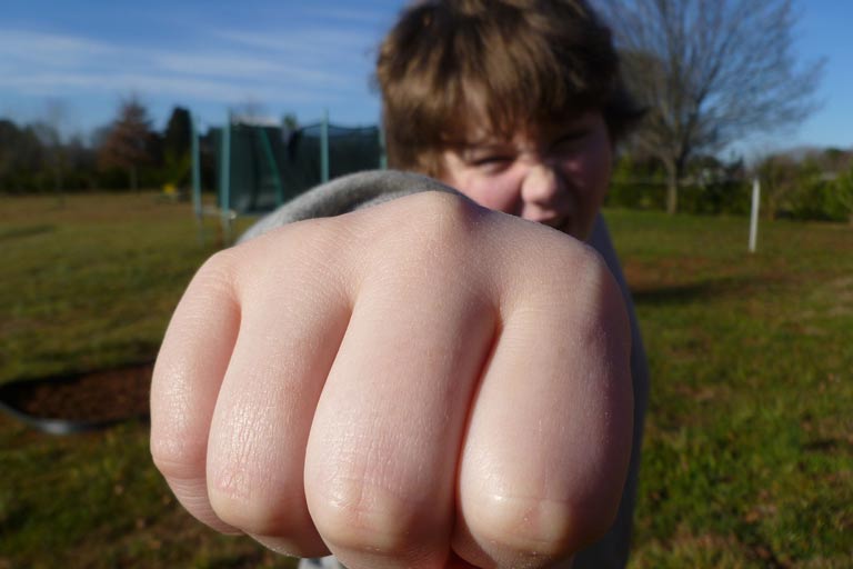 Young boy giving a fist bump to the camera