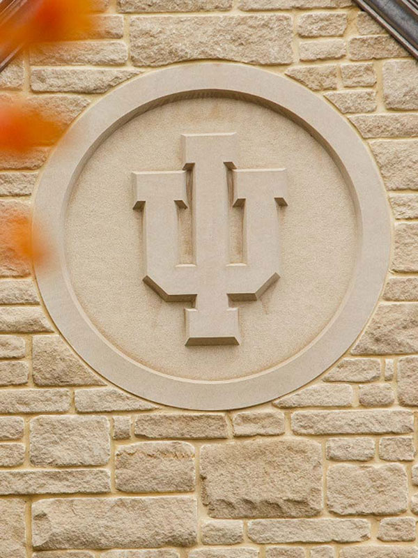 A close-up shot of a limestone seal in the shape of the IU trident.