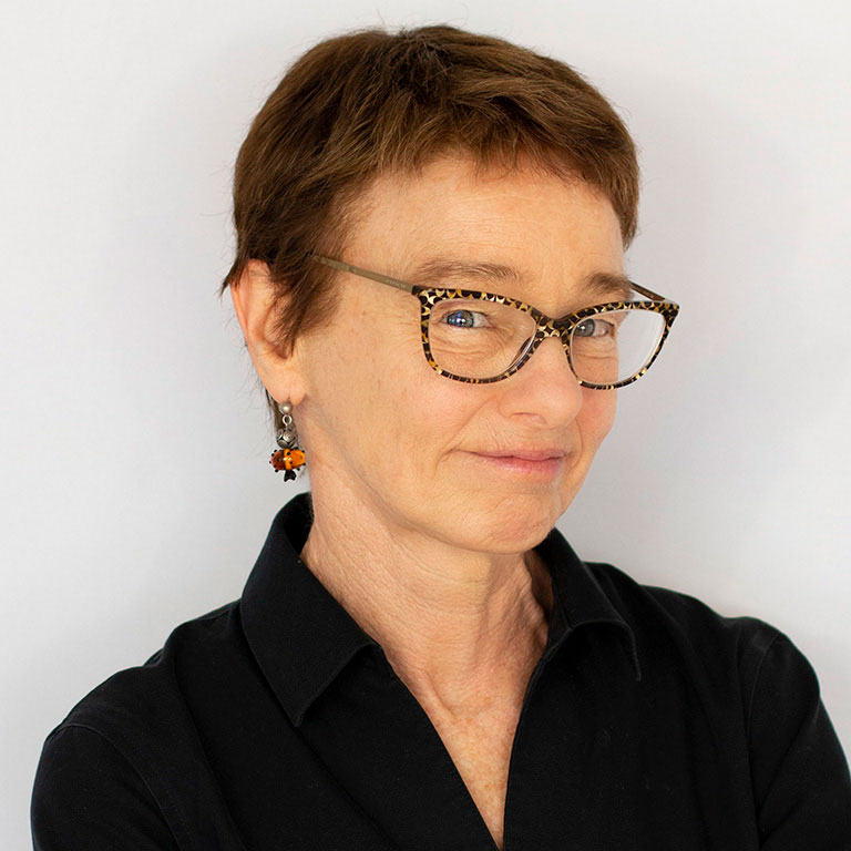A headshot of department chair Patricia McManus, who wears glasses and a black shirt.