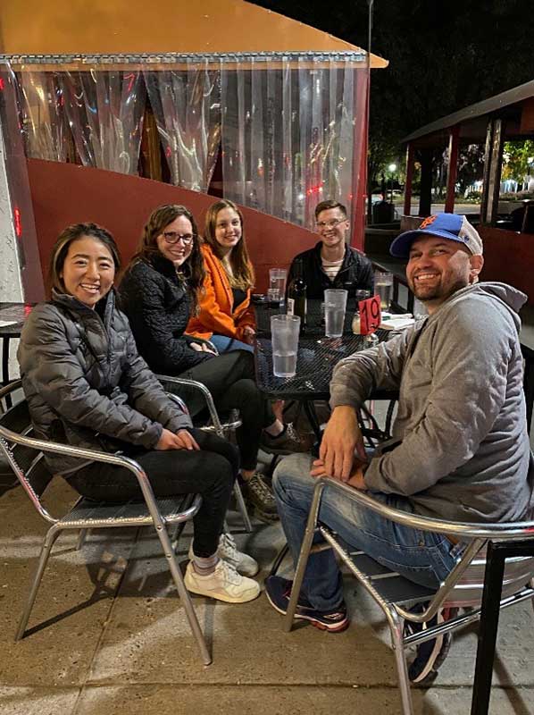A group of IU Sociology students sit at a restaurant table outside.