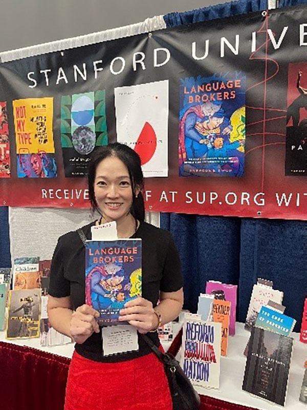 Hyeyoung Kwon posing with her book at a book fair.