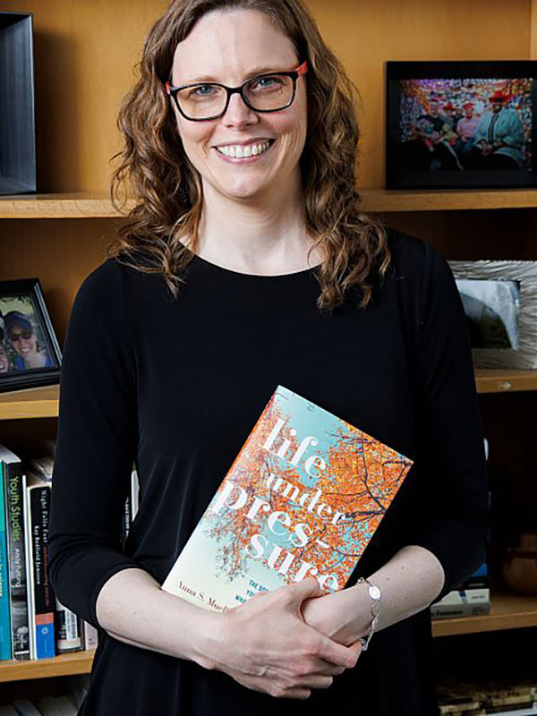 Professor Mueller poses with her book.