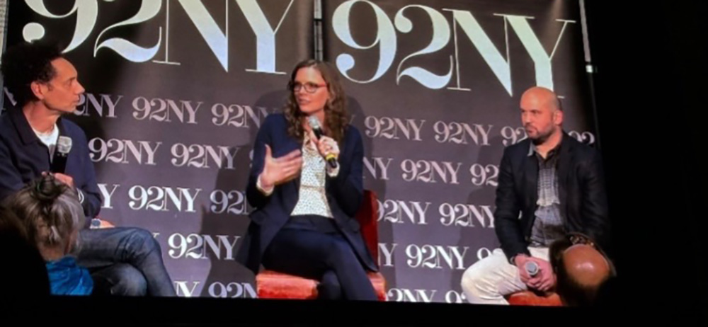 Professor Mueller speaks on stage, in a presentation with Malcolm Gladwell.