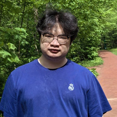 A headshot of Parry Peng, who wears a blue shirt and poses outside.