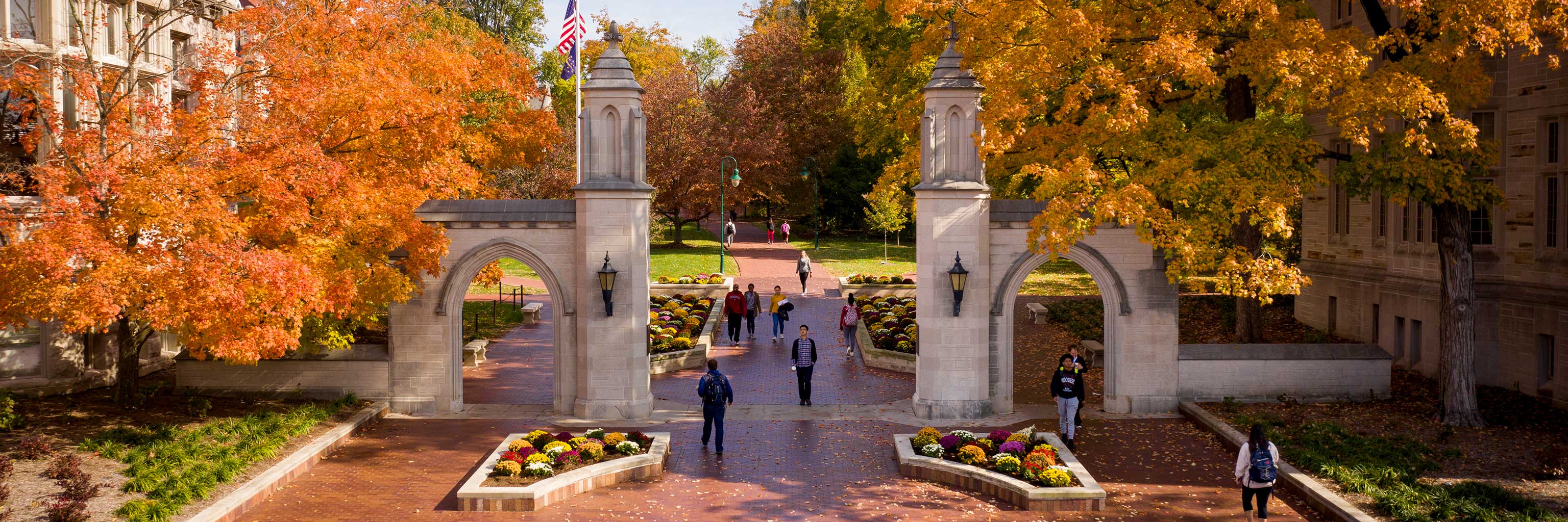 A longshot photo of the Sample Gates, with autumn foliage in the background.